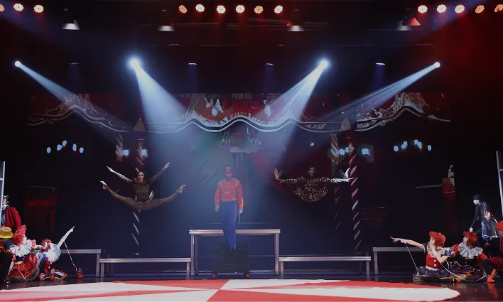Conference stage with beam lighting and a broad presentation backdrop